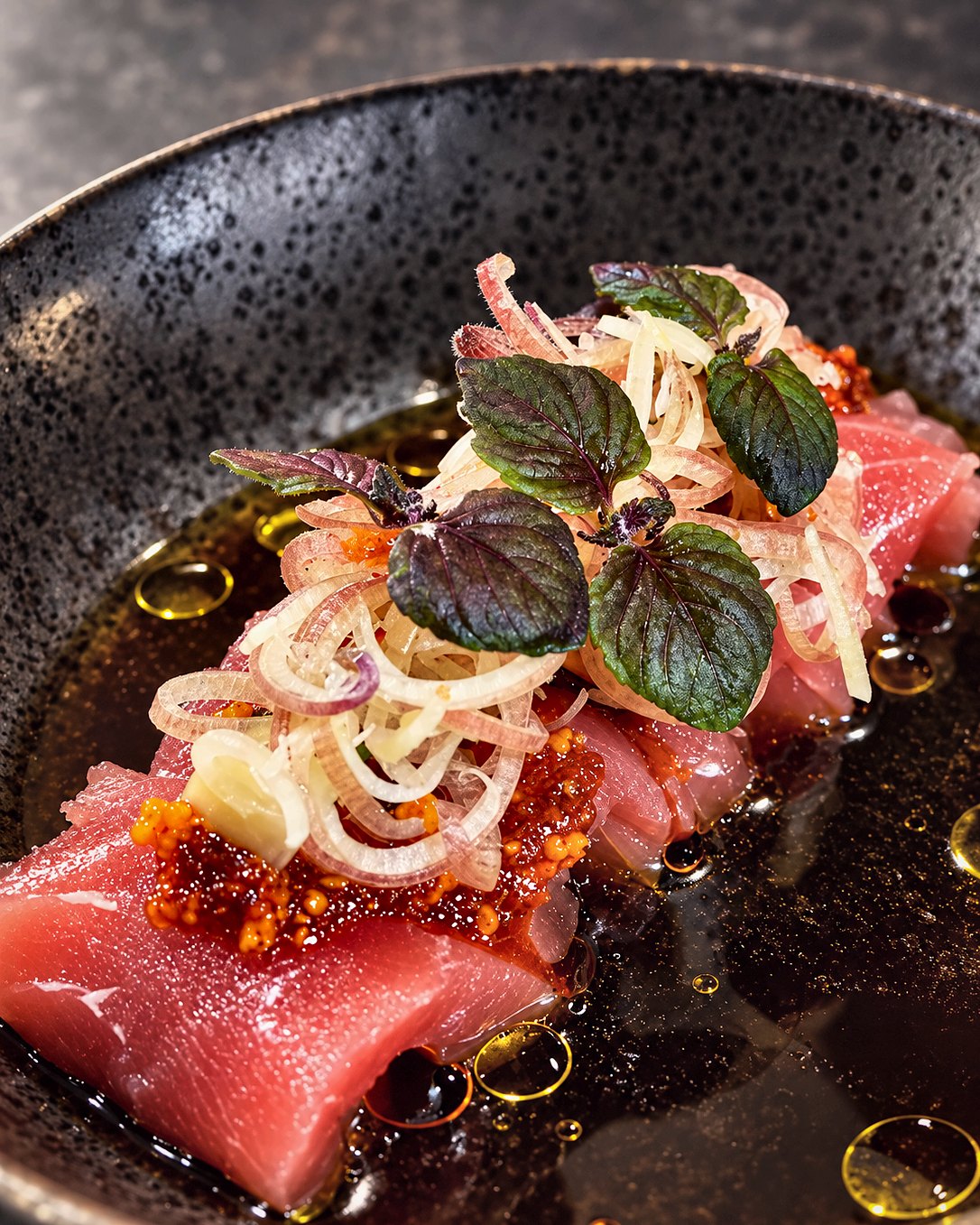 Tuna crudo with shaved shallot and citrus oil, plated by Chef Martin Fassi