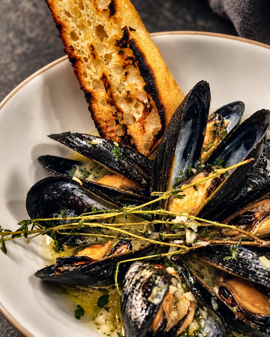 Mussels in herb butter with grilled bread, cooked by Chef Martin Fassi in Houston